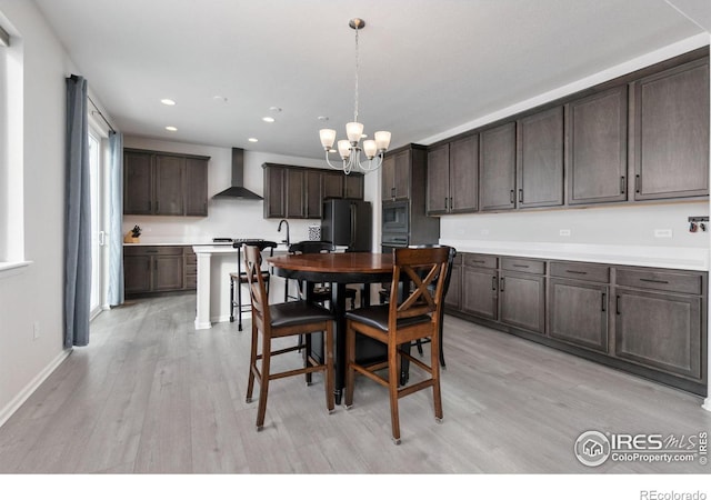 dining space with light hardwood / wood-style floors and a chandelier