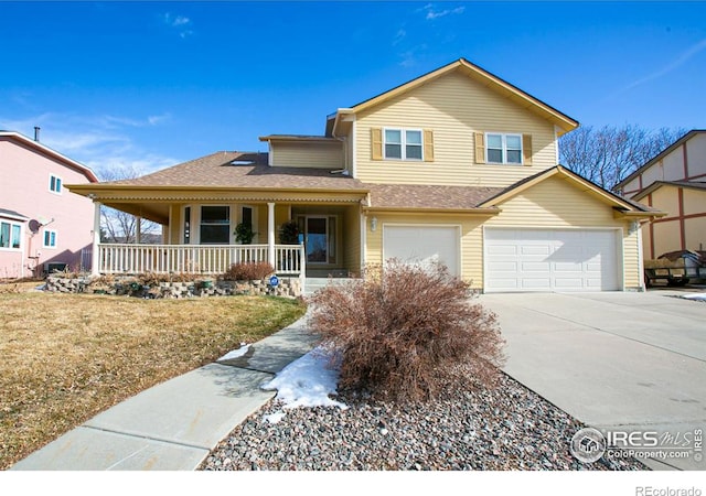 view of front of home featuring a garage, a front lawn, and covered porch