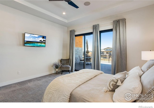 carpeted bedroom featuring a tray ceiling, access to outside, and ceiling fan