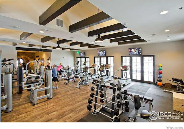 gym with hardwood / wood-style flooring and french doors