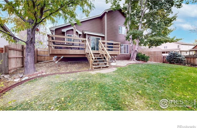 rear view of house with a fenced backyard, stairs, a deck, and a yard