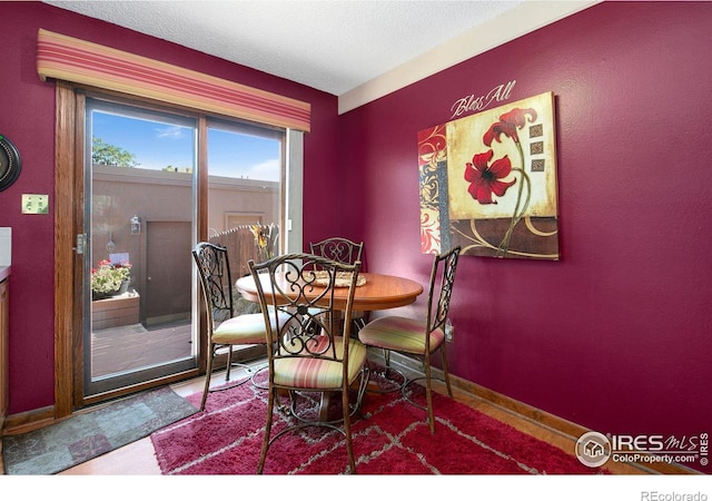 dining space featuring baseboards and a textured ceiling