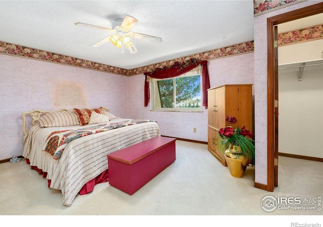 carpeted bedroom featuring wallpapered walls, baseboards, and a textured ceiling