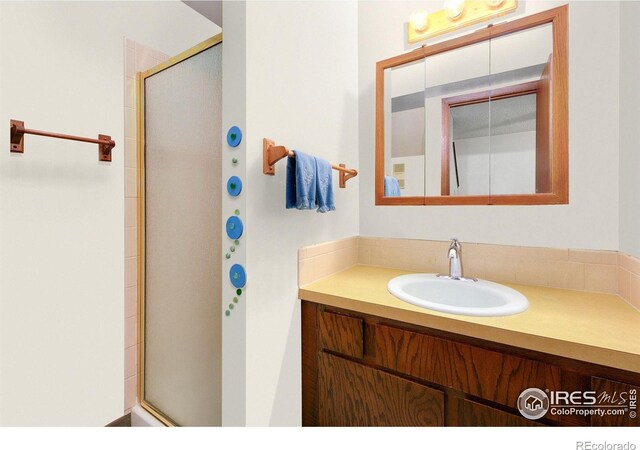 bathroom featuring a shower stall and vanity