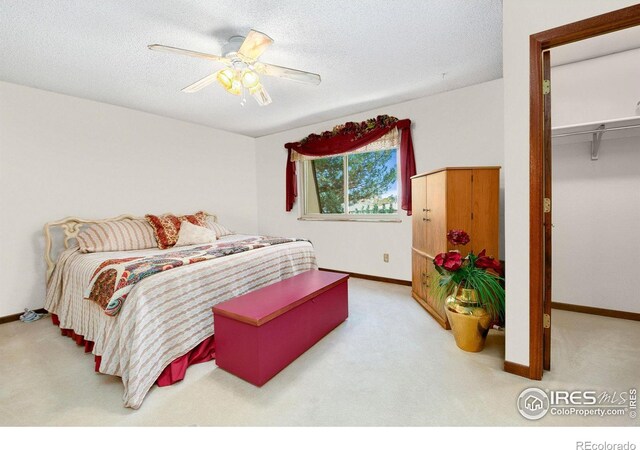 carpeted bedroom with a textured ceiling and baseboards