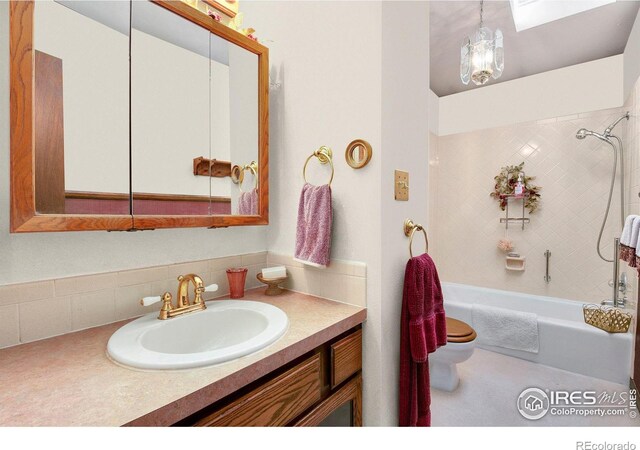 full bath featuring bathing tub / shower combination, a skylight, vanity, and toilet