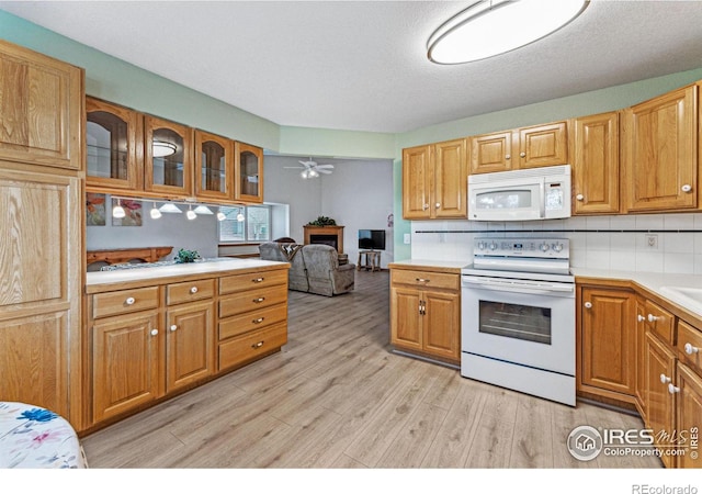 kitchen with ceiling fan, backsplash, white appliances, and light hardwood / wood-style floors