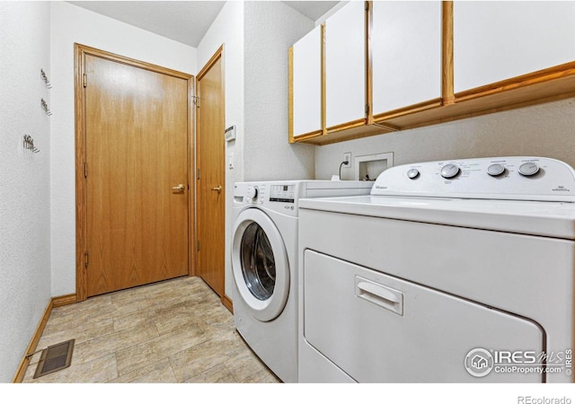 washroom with cabinets and washer and clothes dryer