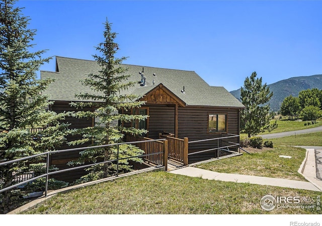 view of front of property with a mountain view and a front lawn