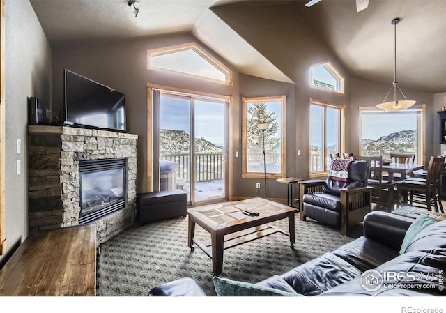 living room with a mountain view, vaulted ceiling, hardwood / wood-style flooring, and a fireplace