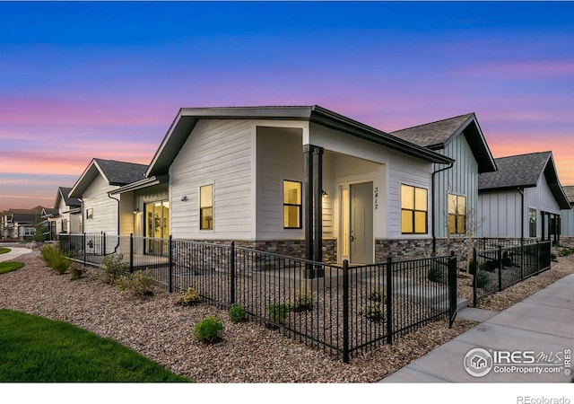 3425 Green Lake Dr, Fort Collins, CO 80524 - view of front of home with stone siding, board and batten siding, and fence private yard