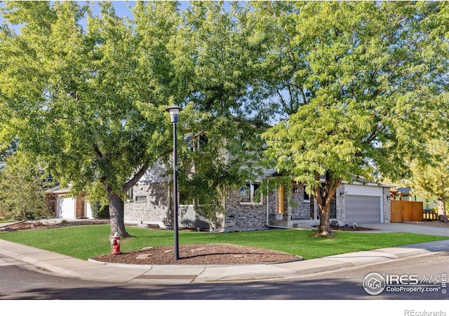 obstructed view of property with a front yard and a garage