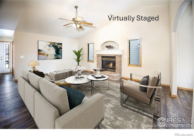 living room featuring a fireplace, a wealth of natural light, vaulted ceiling, and dark hardwood / wood-style flooring