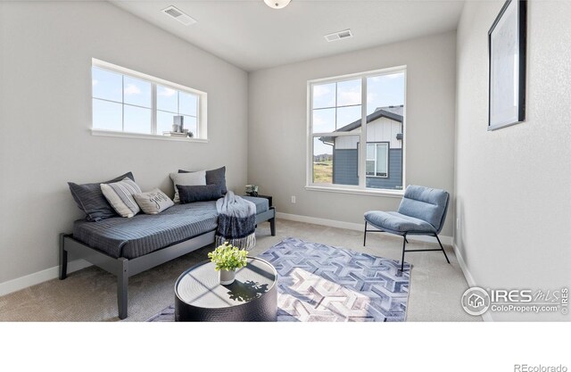 carpeted living room featuring visible vents and baseboards