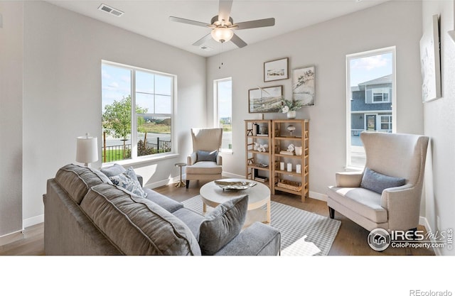 living room with visible vents, baseboards, and wood finished floors