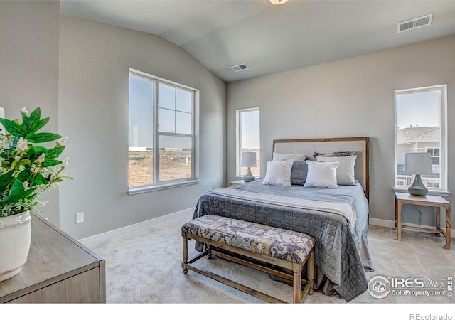 carpeted bedroom with visible vents, vaulted ceiling, and baseboards