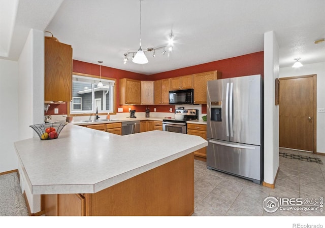 kitchen with sink, stainless steel appliances, hanging light fixtures, and kitchen peninsula