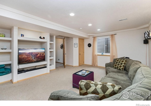 living room featuring built in shelves, carpet, and a textured ceiling