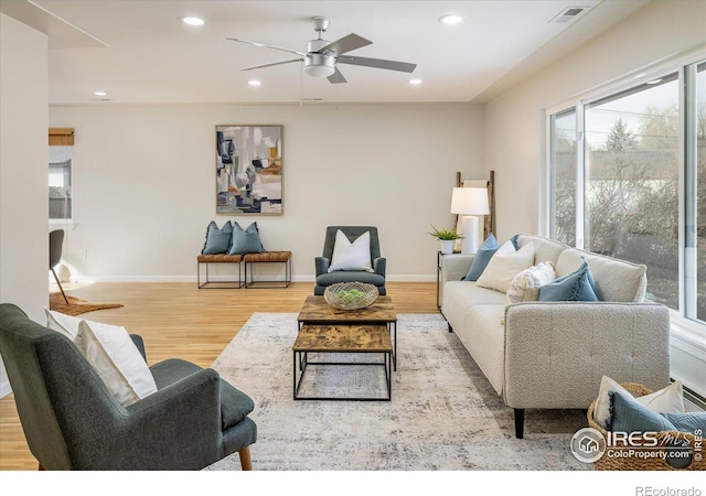 living room featuring ceiling fan and light hardwood / wood-style flooring