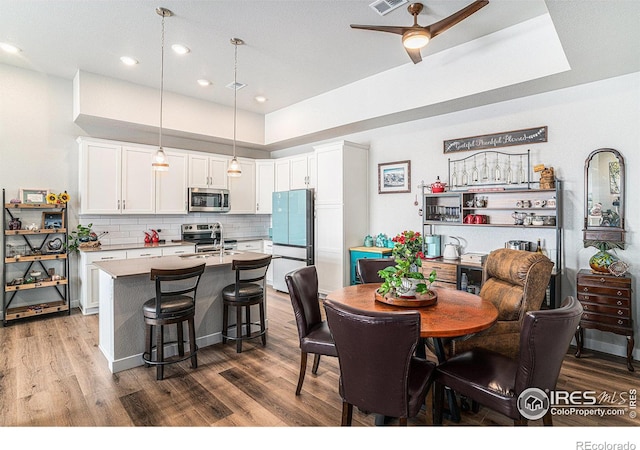 dining space with dark wood finished floors, visible vents, and recessed lighting