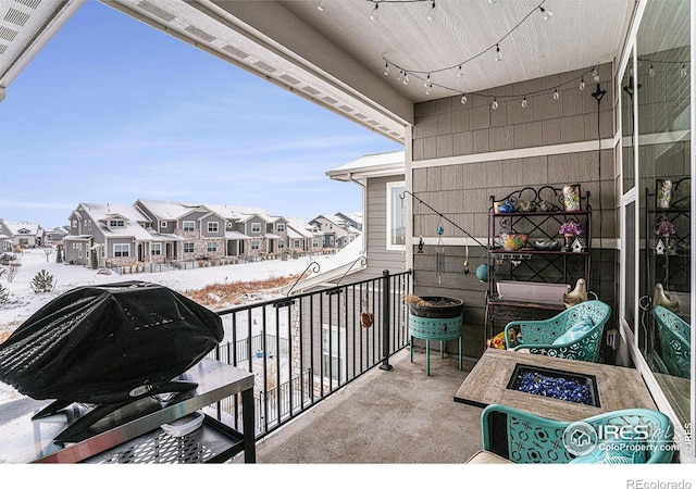 snow covered back of property featuring grilling area