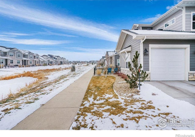 view of snowy exterior featuring a garage