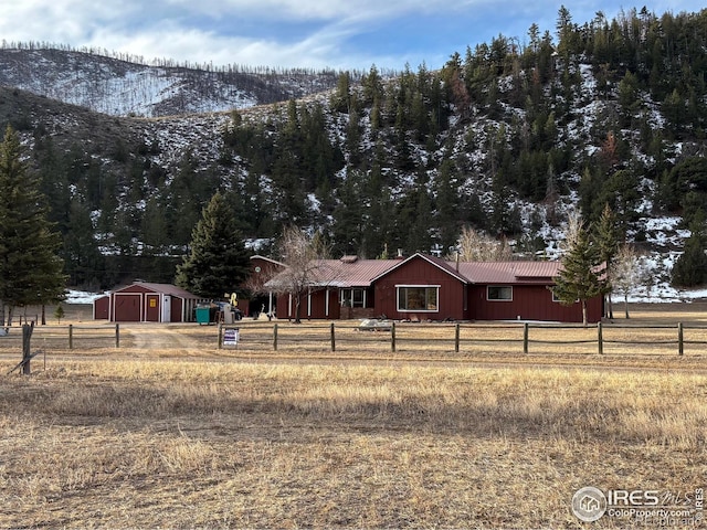 ranch-style house with fence and metal roof