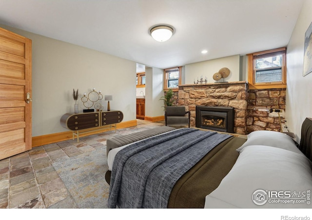 851 14th St, Boulder, CO 80302 - bedroom featuring stone tile floors, baseboards, a stone fireplace, and multiple windows