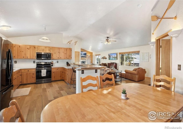 dining area with ceiling fan, lofted ceiling, and light hardwood / wood-style floors