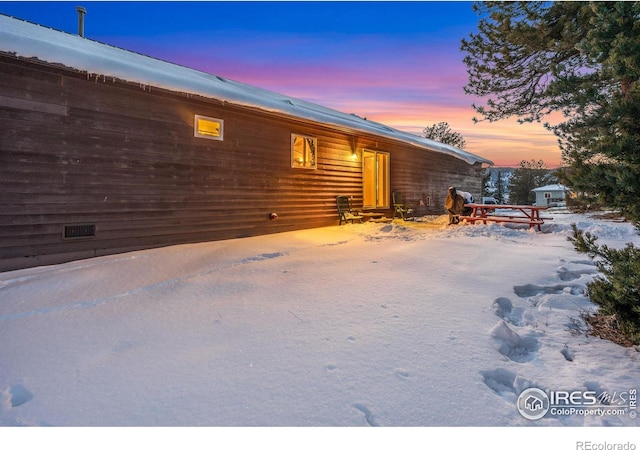 view of snow covered rear of property