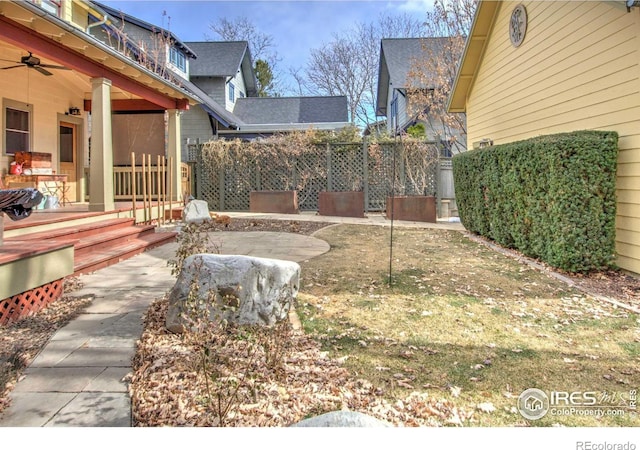 view of yard with ceiling fan and a patio