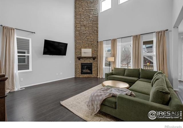 887 Sundance Ln, Erie, CO 80516 - living area with a high ceiling, wood finished floors, and a stone fireplace