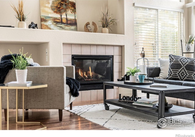 living area featuring wood finished floors and a tiled fireplace