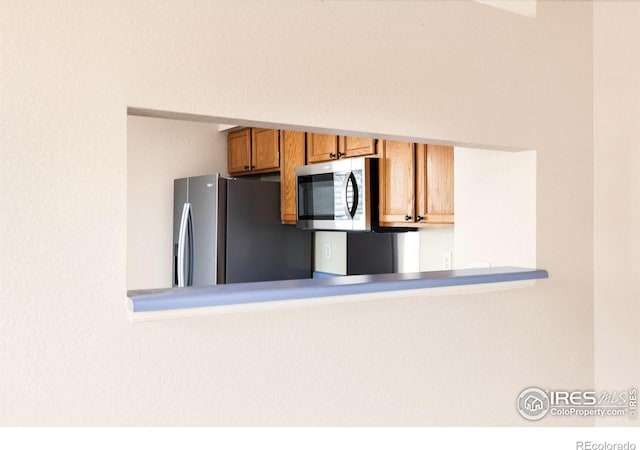 kitchen with brown cabinetry and appliances with stainless steel finishes