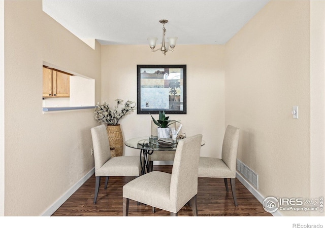 dining space featuring visible vents, baseboards, an inviting chandelier, and dark wood-style flooring