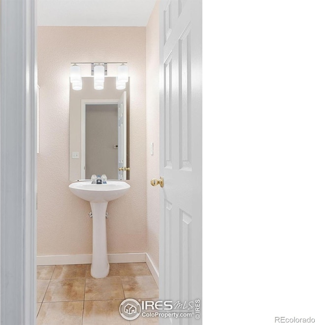 bathroom with tile patterned floors and baseboards