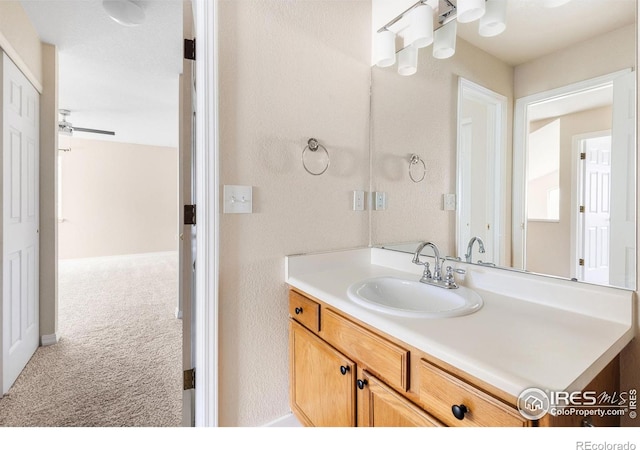 bathroom with vanity and a textured wall