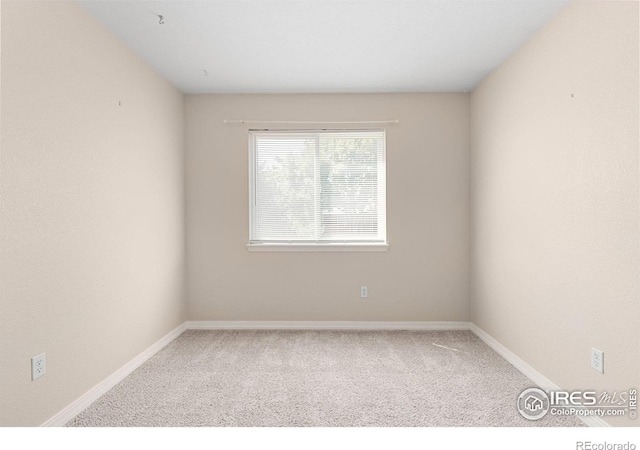 carpeted spare room with baseboards