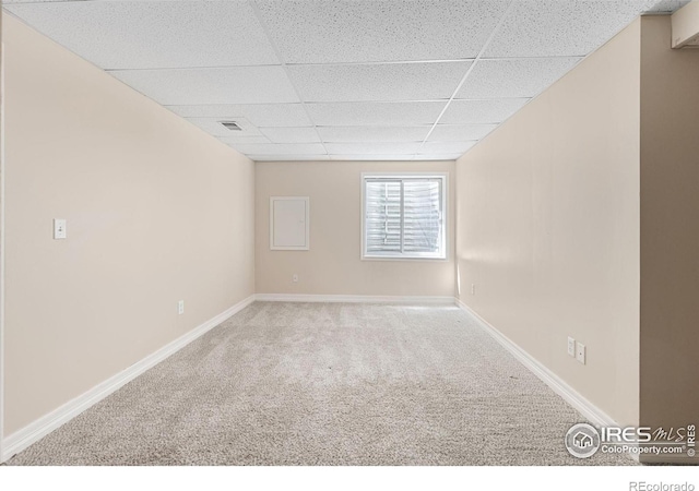 spare room with baseboards, a paneled ceiling, carpet floors, and visible vents