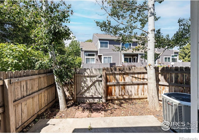 rear view of property featuring cooling unit and fence private yard