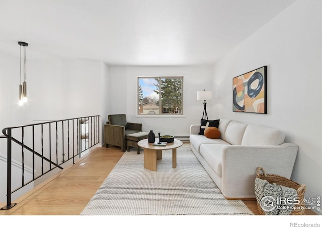 living area with light wood-style floors and baseboard heating