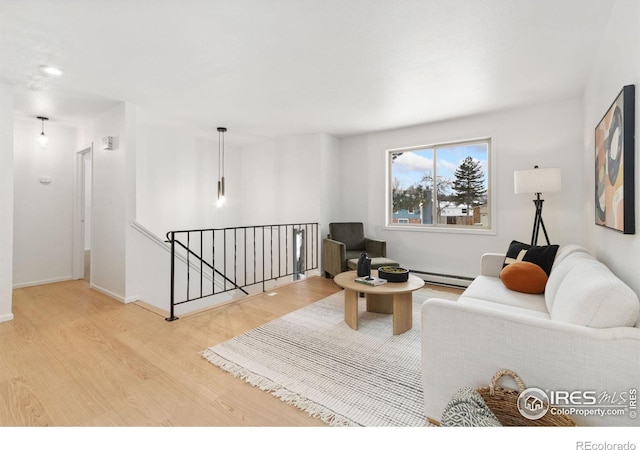 living room featuring light wood-type flooring, baseboards, and a baseboard heating unit