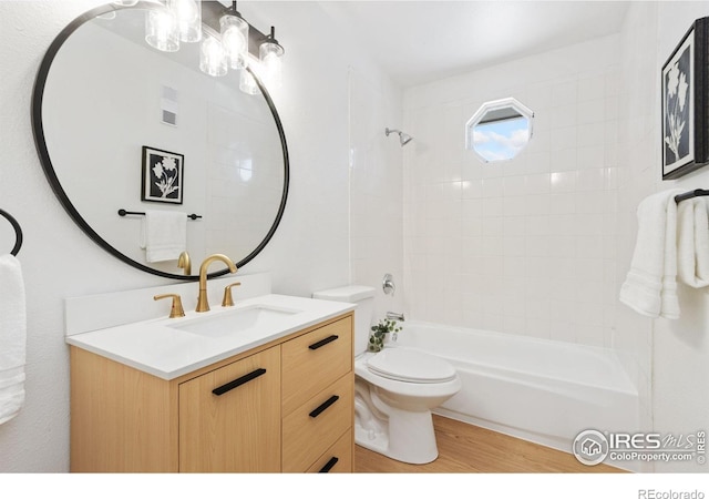 bathroom with toilet, tub / shower combination, wood finished floors, and vanity