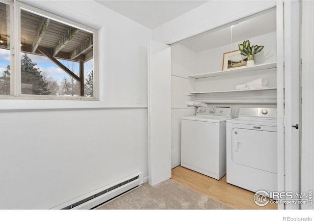 clothes washing area with light wood-style floors, washing machine and dryer, laundry area, and baseboard heating