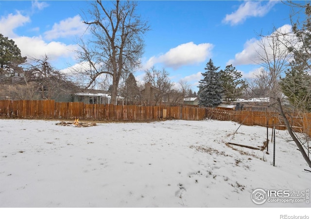 snowy yard featuring fence