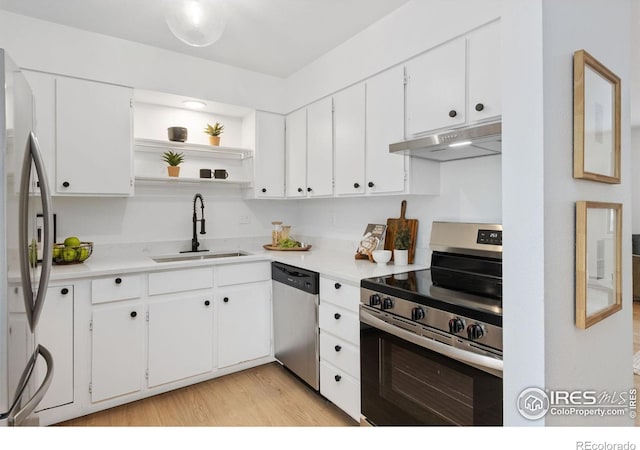 kitchen with light countertops, appliances with stainless steel finishes, white cabinets, a sink, and under cabinet range hood