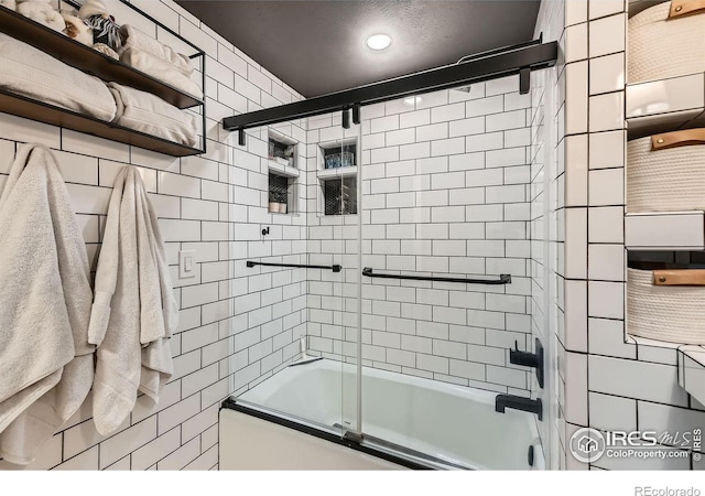 bathroom featuring bath / shower combo with glass door