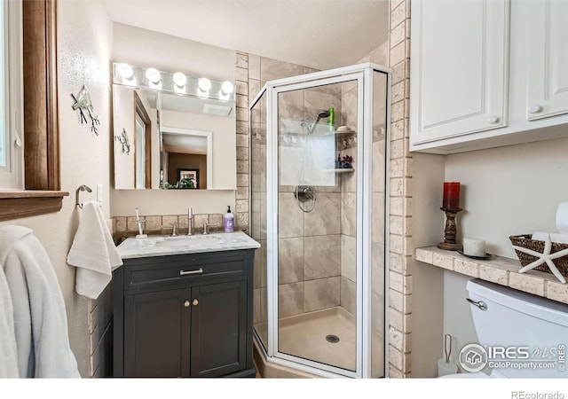 bathroom with toilet, a shower with door, and vanity