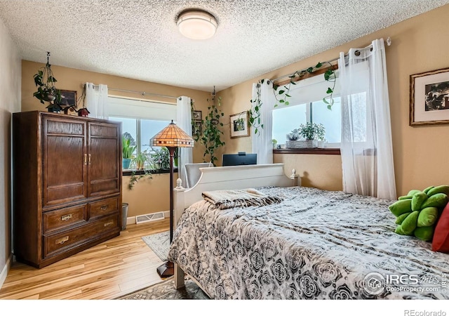 bedroom featuring light wood-type flooring and a textured ceiling