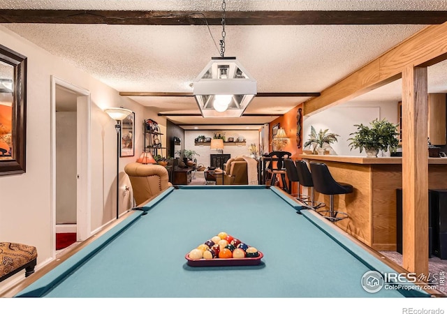 rec room featuring a textured ceiling and bar